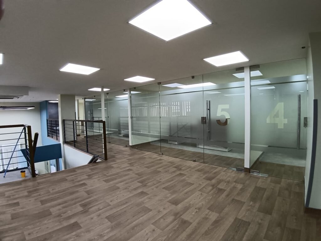 Piso vinílico instalado en oficinas corporativas con divisiones de vidrio